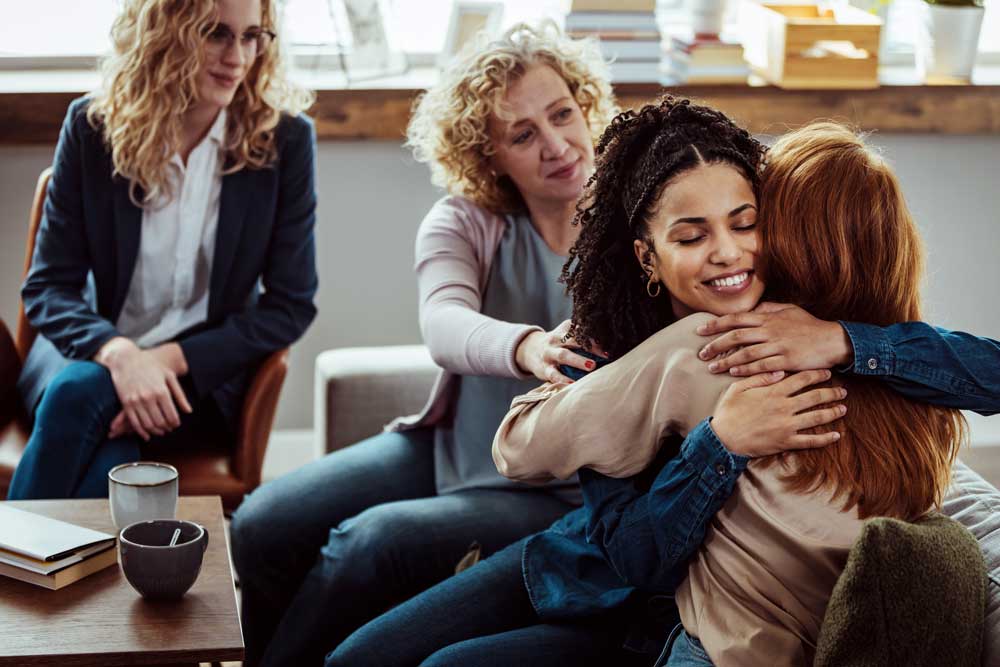 women in group therapy supporting each other