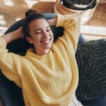 Happy woman leaning back on chair with hands behind head