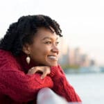 woman outside looking out into the ocean and thinking