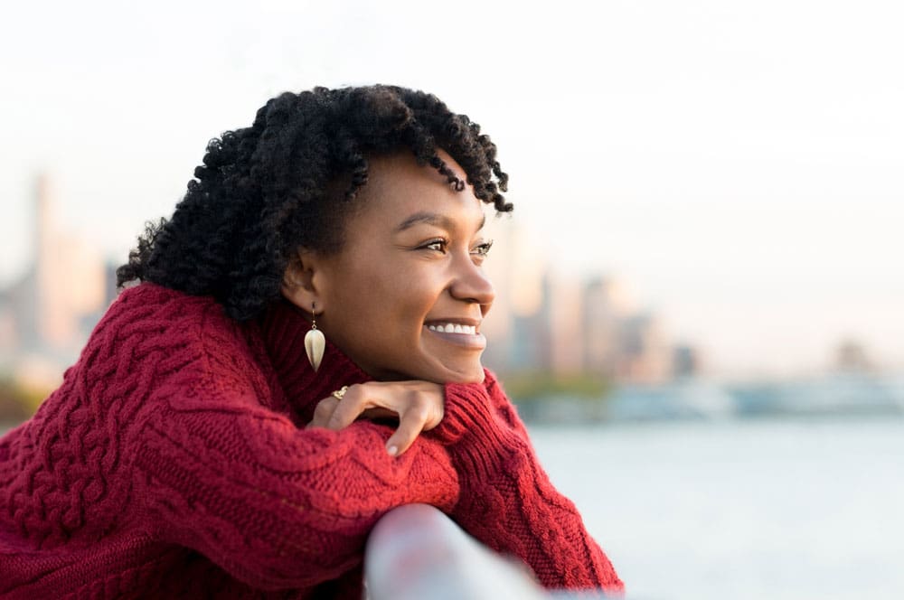 woman outside looking out into the ocean and thinking