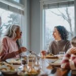 A multigenerational family enjoying a holiday meal together, sharing laughter and conversation around a dining table filled with food.